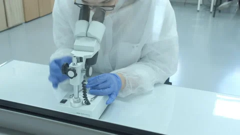 Scientist working with microscope in manufacturing laboratory Stock Footage 152447794