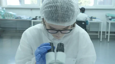 Scientist working with microscope in manufacturing laboratory Stock Footage 152447824