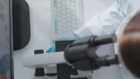The scientist works at the keyboard and at the computer at the table. Woman Stock Footage 263153717
