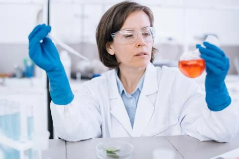 Scientist works in the lab with different testing tube in her hand. Stock Photos