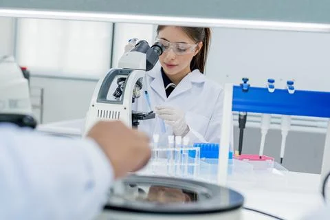 Scientist works in a laboratory using a microscope to conduct research and .. Fotos de archivo