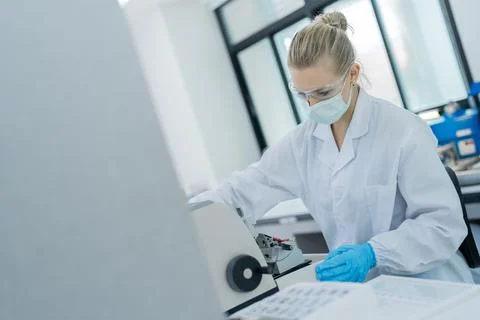 Scientist works in laboratory using microscope to analyze samples under bri.. Фото