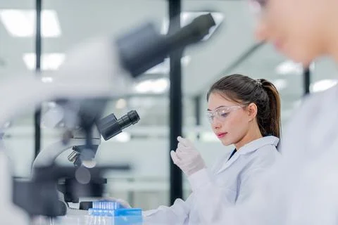 Scientist works in laboratory while analyzing samples with microscope durin.. Stock Photos