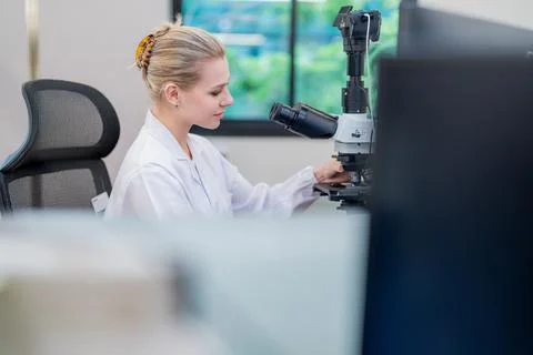 Scientist works at microscope in laboratory during the day conducting resea.. Stock Photos
