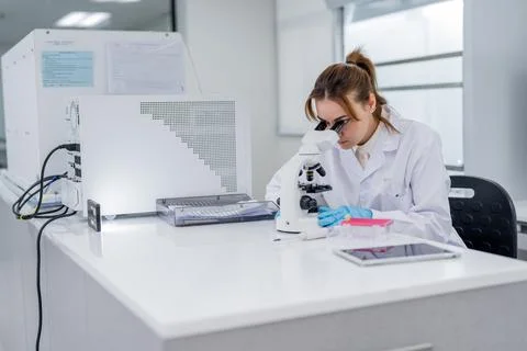 Scientist works with microscope in laboratory setting during daytime in mod.. Fotos Stock