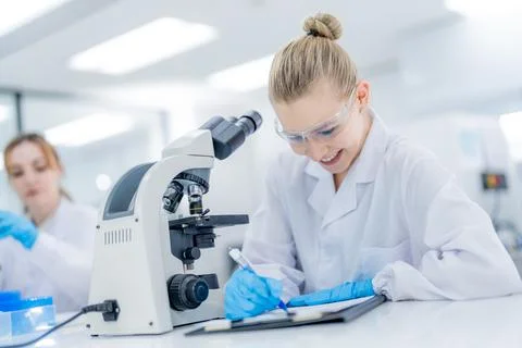 Scientist works at microscope while conducting research in laboratory durin.. Stock Photos