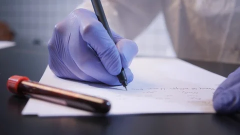 Scientist writes report on coronavirus at table closeup Stock Footage 126952533