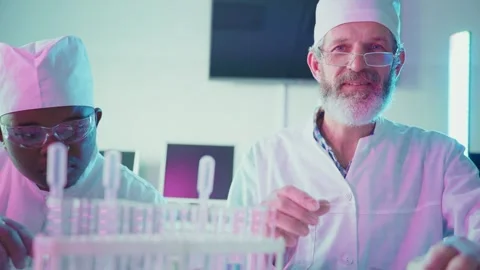 Scientists analyzing test tubes in laboratory Stock Footage 306584537