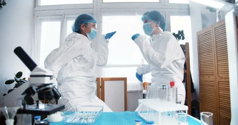 Scientists celebrating success. Two fun happy mixed race female doctors in Stock Footage 151907569