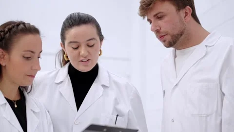 Scientists checking results on a notepad Video stock 255196423