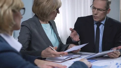 Scientists comparing graphics of population growth with tablet data in office Stock Footage 83552221