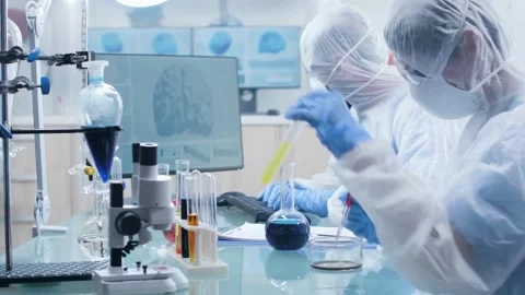 Scientists Conducting Chemical Experiments with Liquid Samples Stock Footage 325824440