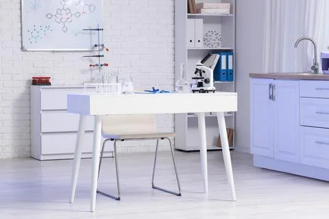Scientist's desk with microscope and water samples in laboratory Фото