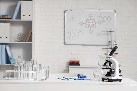 Scientist's desk with microscope and water samples in laboratory Фото
