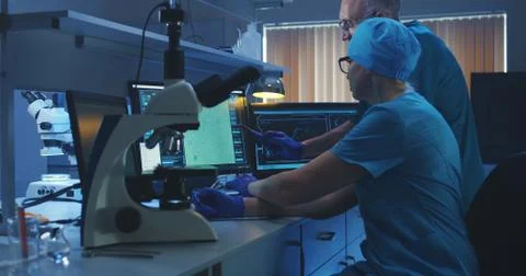 Scientists examining bacteria with microscope Stock Photos