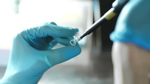 A scientists hands dripping a sample into an eppindorf with pipette. Video stock 294535833