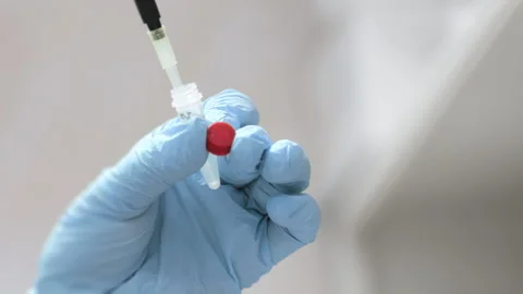 A scientists hands dripping a sample into an eppindorf with pipette. Stock Footage 294535973