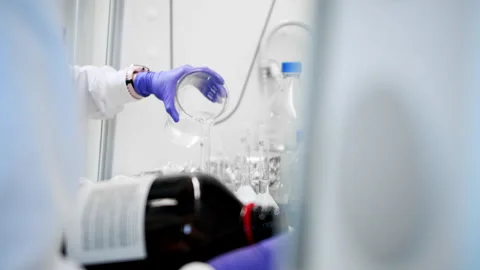 Scientists in lab are pouring over the liquid in containers in the search Stock Footage 264239439