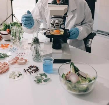 Scientists in lab coats work with plants in a modern lab, focusing on resea.. Stock Photos