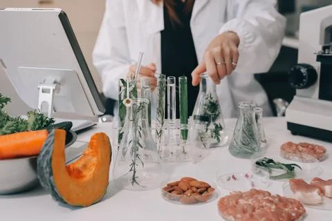 Scientists in lab coats work with plants in a modern lab, focusing on resea.. Stock Photos
