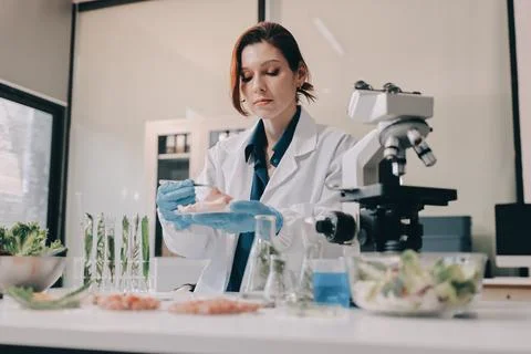 Scientists in lab coats work with plants in a modern lab, focusing on resea.. Stock Photos
