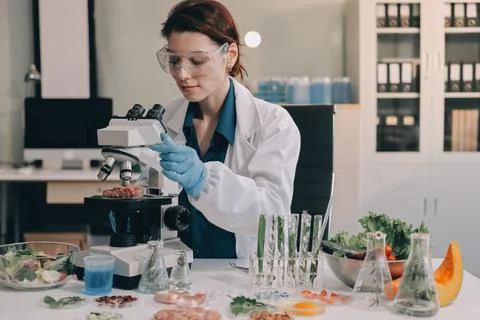 Scientists in lab coats work with plants in a modern lab, focusing on resea.. Stock Photos