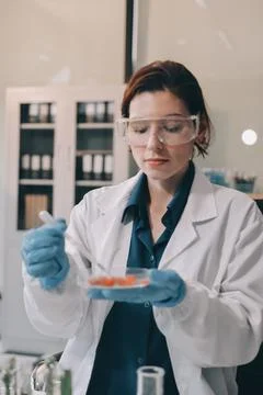 Scientists in lab coats work with plants in a modern lab, focusing on resea.. Stock Photos