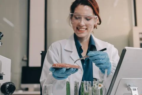 Scientists in lab coats work with plants in a modern lab, focusing on resea.. Stock Photos