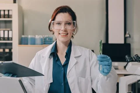 Scientists in lab coats work with plants in a modern lab, focusing on resea.. Stock Photos