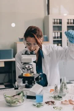 Scientists in lab coats work with plants in a modern lab, focusing on resea.. Stock Photos