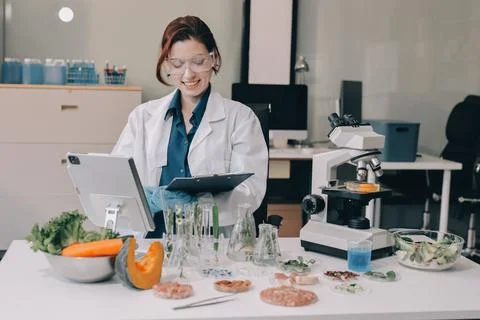 Scientists in lab coats work with plants in a modern lab, focusing on resea.. Stock Photos