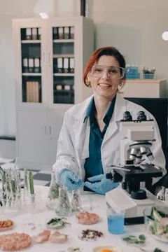 Scientists in lab coats work with plants in a modern lab, focusing on resea.. Stock Photos
