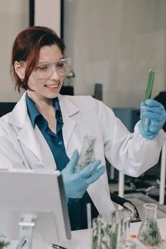 Scientists in lab coats work with plants in a modern lab, focusing on resea.. Stock Photos