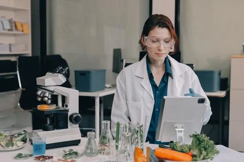 Scientists in lab coats work with plants in a modern lab, focusing on resea.. Stock Photos