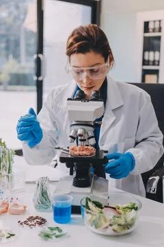 Scientists in lab coats work with plants in a modern lab, focusing on resea.. Stockfoto's