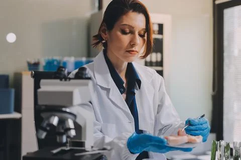 Scientists in lab coats work with plants in a modern lab, focusing on resea.. Stockfoto's