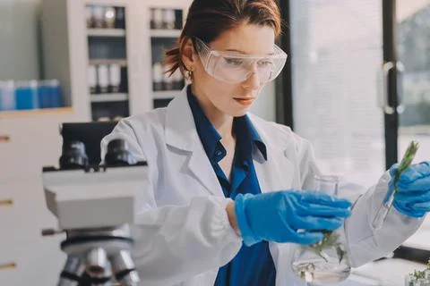 Scientists in lab coats work with plants in a modern lab, focusing on resea.. Stockfoto's