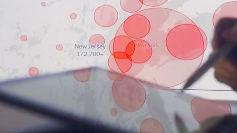 Scientists look at Covid-19 map of the USA on computer Stock Footage 136103120