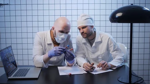 Scientists look at tubes with samples of coronavirus in lab Stock Footage 126952416