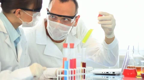 Scientists looking at test tubes and writing results on laptop HD Video stock 5089718