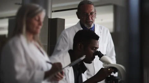 Scientists In Microscope Look at screen Stock Footage 62944993