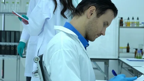 Scientists observe and record the experiment in modern laboratory. Stock Footage 112056379