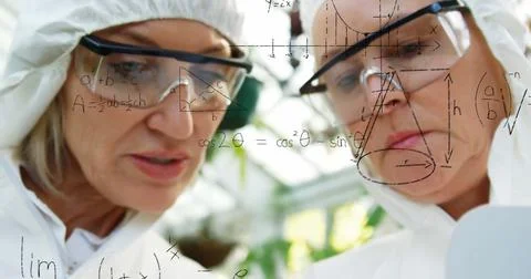 Scientists in protective gear analyzing data on transparent screen in laboratory Stock Photos