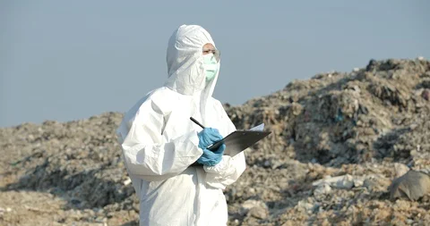 Scientists in protective suits makes inspection in landfill. Video stock 129844552