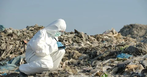Scientists in protective suits makes inspection in landfill. Stock Footage 129844599