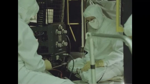 Scientists in protective work wear discuss over Hubble Space Telescope - 1988 Stock Footage 104333677