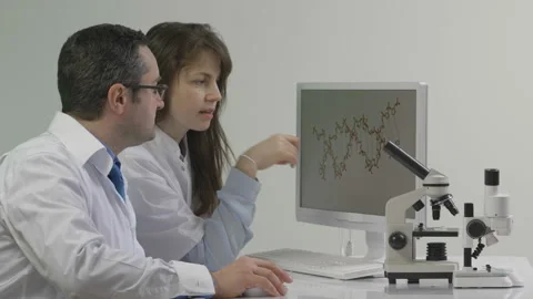 Scientists researching DNA mutation on microscope monitor in the lab Stock Footage 196111909