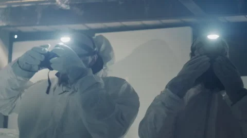 Scientists study debris. Researchers in protective gear meticulously extract Stock Footage 346475045