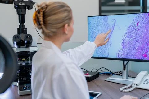 Scientists study tissue sample under microscope in laboratory setting with .. Stock Photos