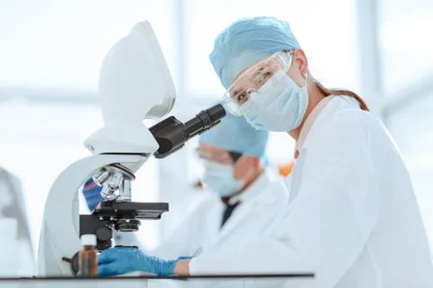 Scientists testing the liquid and writing the results in a laboratory journal. Stock Photos